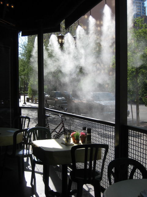 Misting line cooling an outdoor café dining area