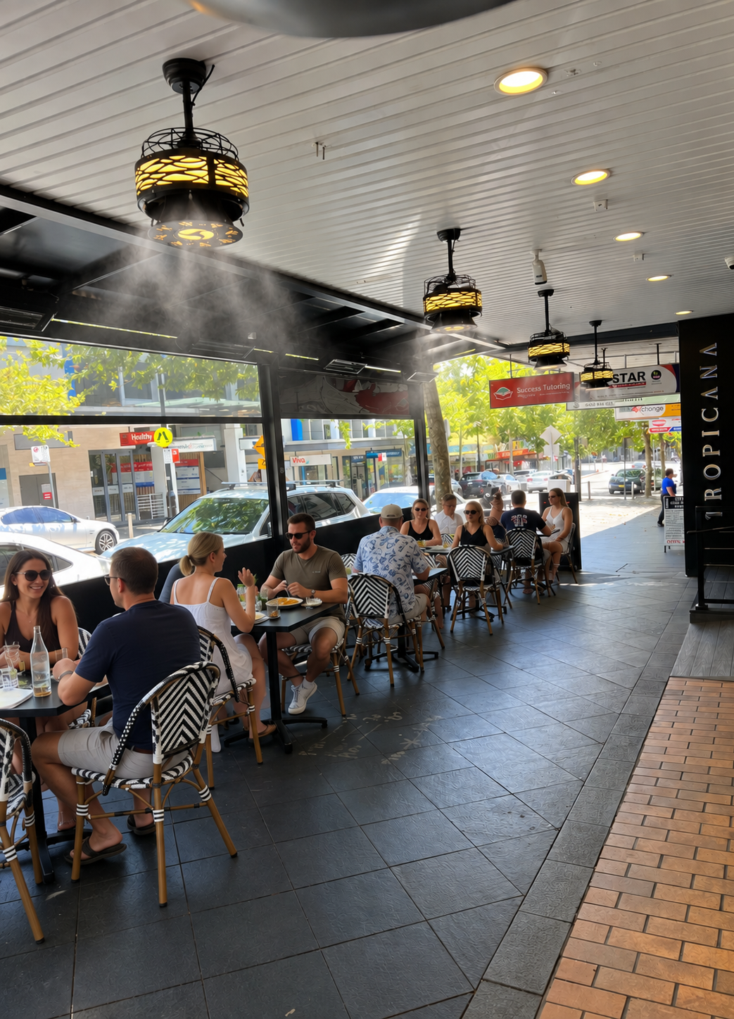 LuxMist ceiling misting fans cooling diners in a café